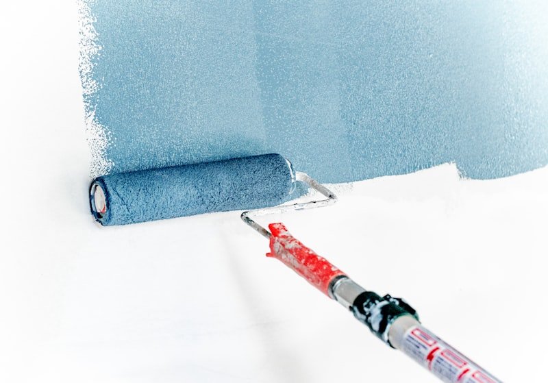 Rolo de pintura aplicando tinta azul